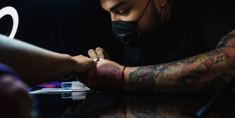 Tattoo artist tattooing a minor